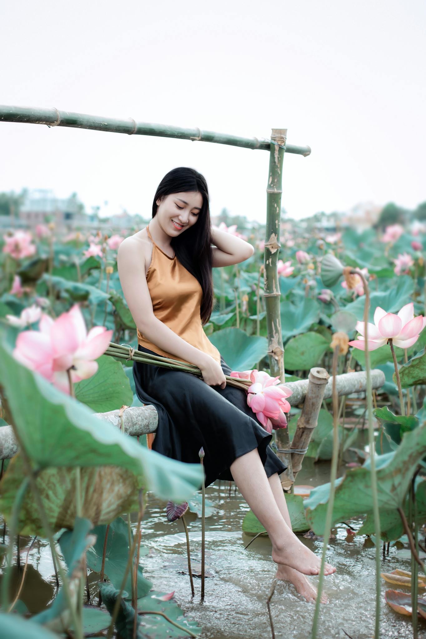 A serene moment of a woman in a lotus field in Hội An, Vietnam.